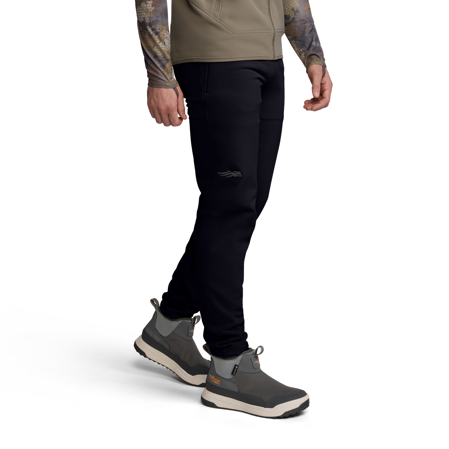 Person wearing black pants and gray shoes on a white background