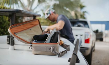 Angler organizing gear using the Fishpond Dakota Rod and Reel Case on the back of a vehicle outdoors
