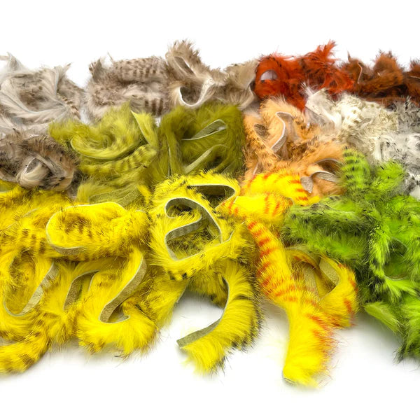 Assorted Hareline Barred Magnum Rabbit Strips in multiple natural and fluorescent colors, featuring bold barring and soft fur for fly tying.
