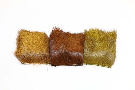 Three dyed elk hair patches from Hareline in natural golden, brown, and olive tones, ideal for tying high-floating dry flies and attractor patterns.