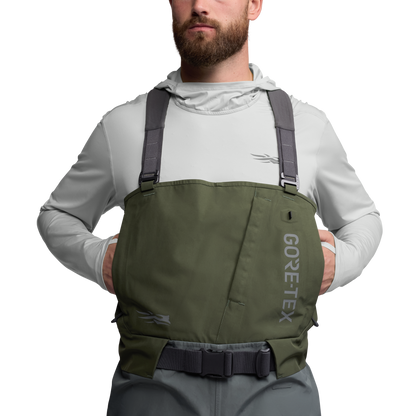 Front view of the Sitka Crosscurrent GTX Stockingfoot Wader worn by a model with hands in chest pocket.